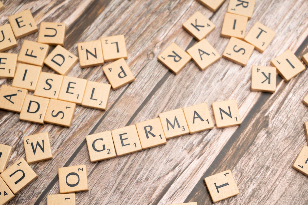 The Art of Drawing Readers In: Your attractive post title goes here Wooden letter tiles on a table spelling out 'German'. Perfect for language, culture, or typography themes.